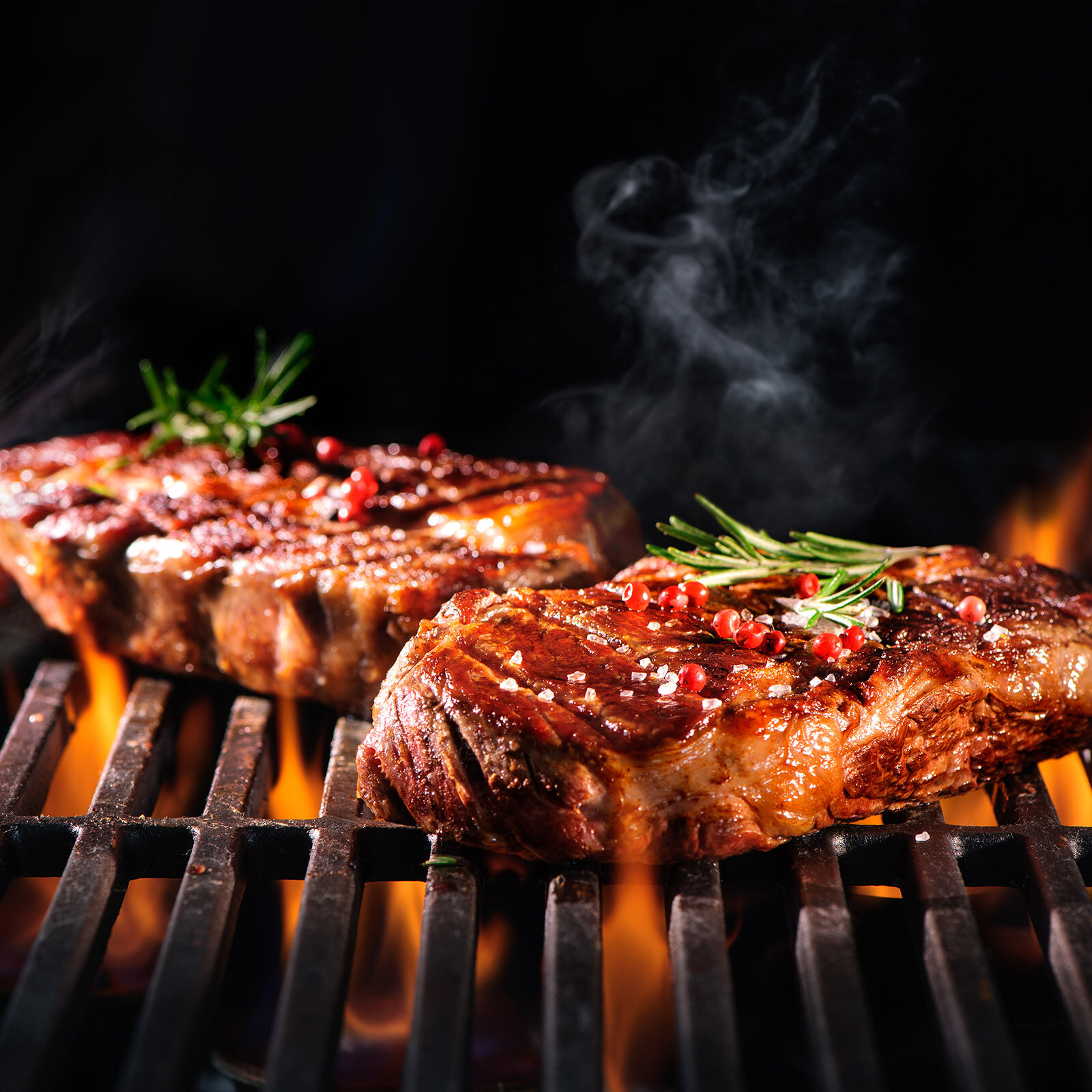 Beef steaks on the grill with flames